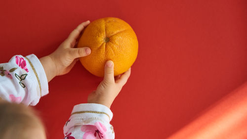 Midsection of woman holding orange