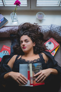 Portrait of woman holding paper at home