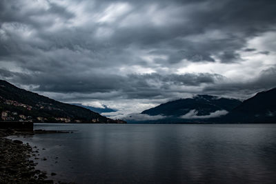 Scenic view of lake and mountains against cloudy sky