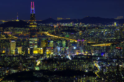 Illuminated city against sky at night