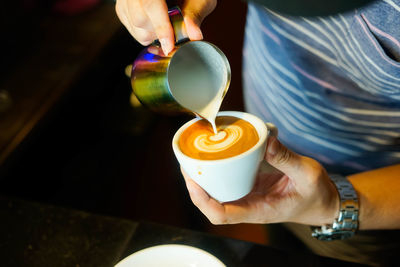 Cropped image of hand holding coffee cup