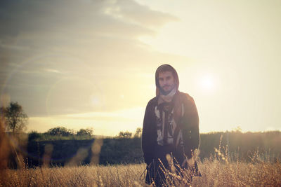 Portrait of man with arms raised at sunset