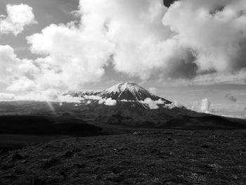 Scenic view of snowcapped mountain against cloudy sky