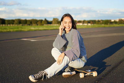 Portrait of young woman standing on road