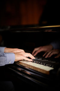 Cropped image of person playing piano