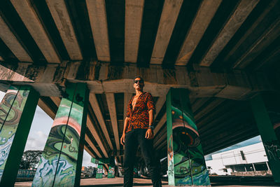 Low angle view of man standing on bridge