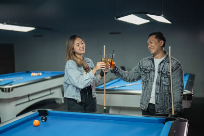 Portrait of young woman playing pool