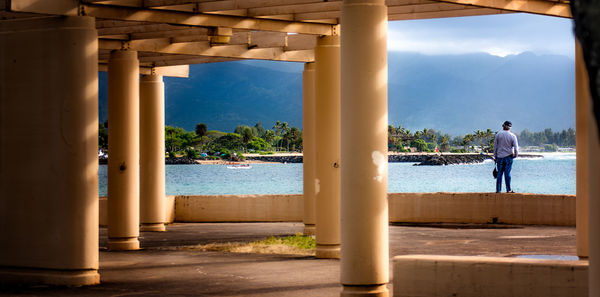 Rear view of man looking at sea against sky