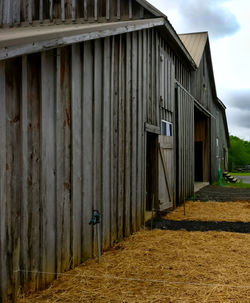 Exterior of old building by field against sky