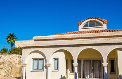 Low angle view of building against clear blue sky