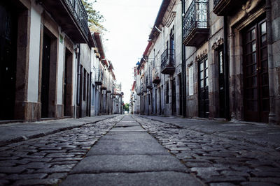 Alley amidst street against sky