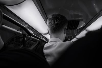 Rear view of man traveling in bus