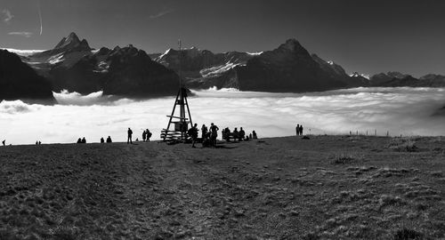 Group of people on beach against mountain range