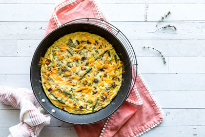 A homemade bacon and asparagus frittata on a cooling rack, ready for serving.