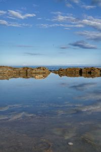 Scenic view of rocky beach against sky