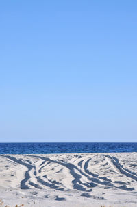 Scenic view of beach against clear blue sky