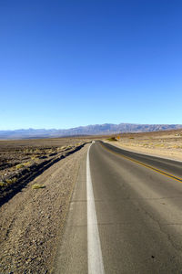 Empty road along countryside landscape