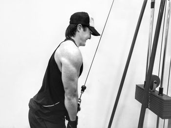 Side view of man exercising pushdown in gym