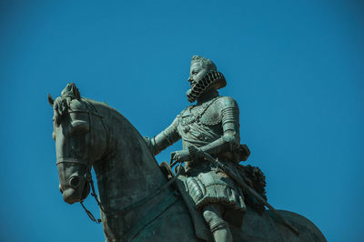 Low angle view of statue against clear blue sky