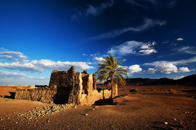 Built structure by atlas mountains at erg chebbi against sky