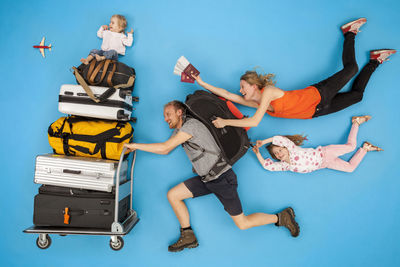 Family with luggage trolley hurrying for departure