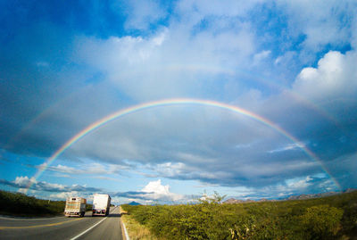 Scenic view of rainbow over land against sky