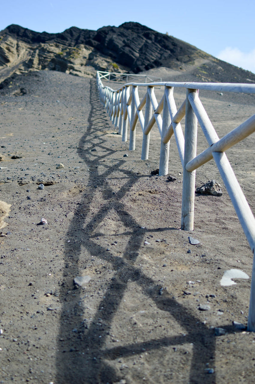 SHADOW OF RAILING ON SANDY BEACH