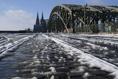 Melting snow on a paved path in cologne, germany, with the famous cathedral in the background