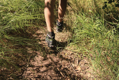 Low section of man walking on field