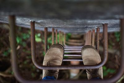 Cropped image of legs on metallic ladder