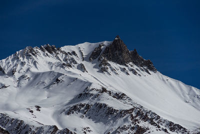 Scenic view of snowcapped mountains against clear blue sky