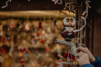 Cropped hands arranging decorations for sale at store