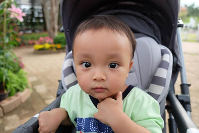 Portrait of cute boy sitting outdoors