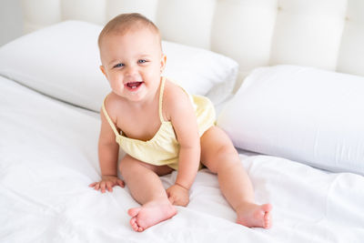 Portrait of cute baby boy lying on bed at home