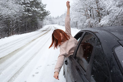 Rear view of woman standing on snow