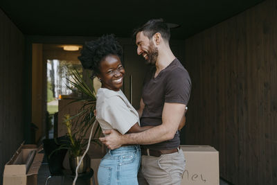 Portrait of cheerful woman laughing with multiracial boyfriend