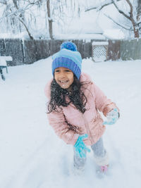 Portrait of young woman standing on snow