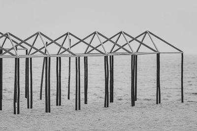 Close-up of metallic structure on beach against clear sky