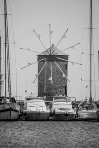 Sailboats moored in sea against sky