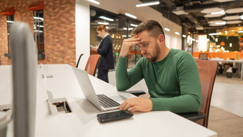 Businesswoman using laptop while sitting on table