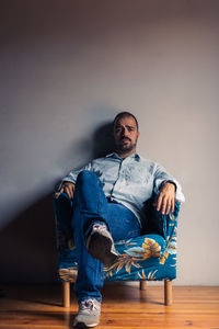 Portrait of man sitting on chair at home