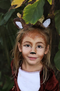 Close-up portrait of a girl with green leaves