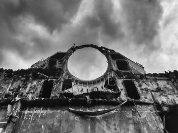 Low angle view of old abandoned building against sky