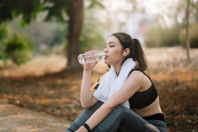 Side view of a young woman drinking drink