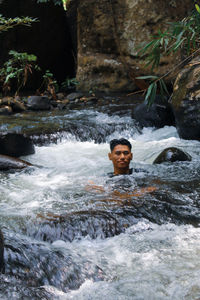 Portrait of young man standing on rock