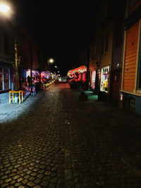 Street amidst buildings in city at night