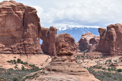 Rock formations on landscape against cloudy sky