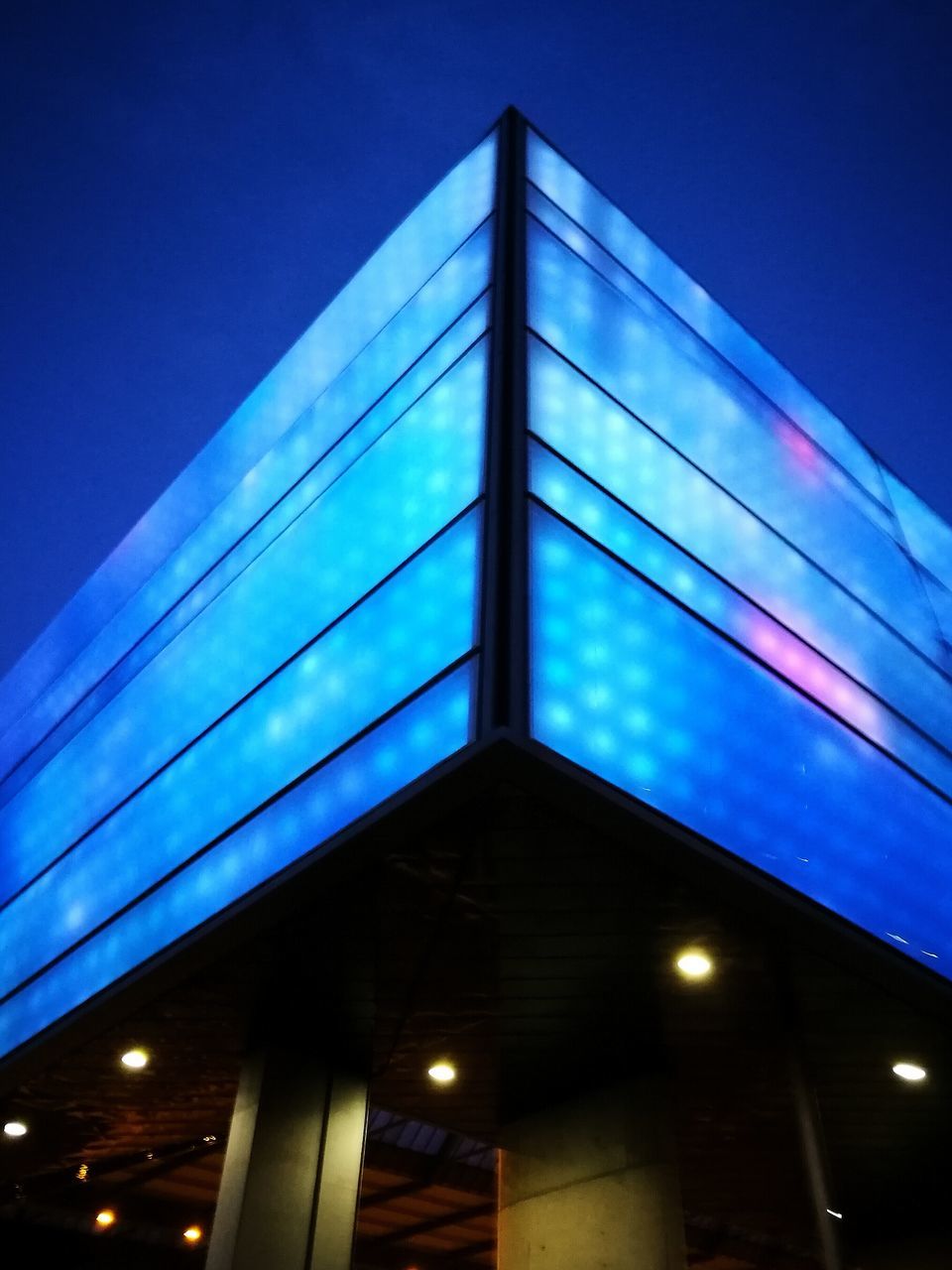 low angle view, illuminated, night, blue, architecture, built structure, connection, no people, outdoors, sky, clear sky, building exterior