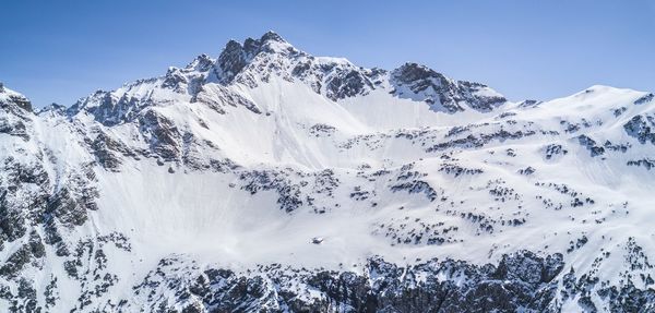 A mountain peak with a small hut in a snowy winter.