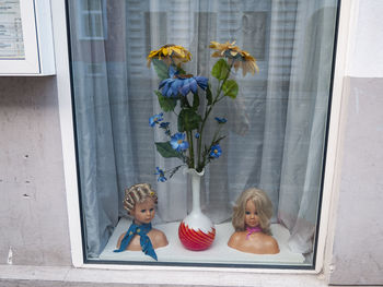 Full frame shot of girl with flowers in glass window